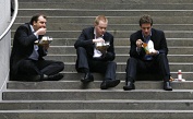 Drei Arbeitskollegen essen auf Stufen sitzend (Bild: Reuters)